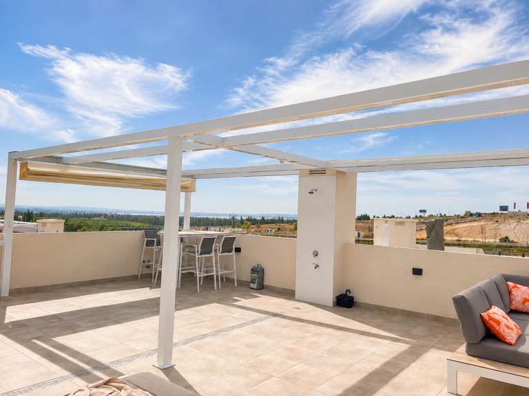 Zonnig dakterras met pergola, loungebank, bartafel en buitendouche, uitkijkend over de Costa Blanca landschap